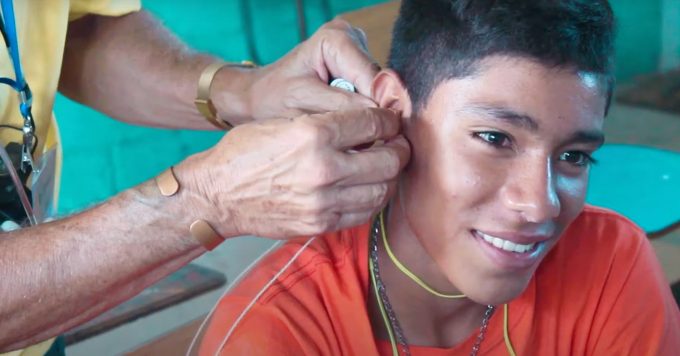 Rodger receives hearing aids provided by Mite donors.