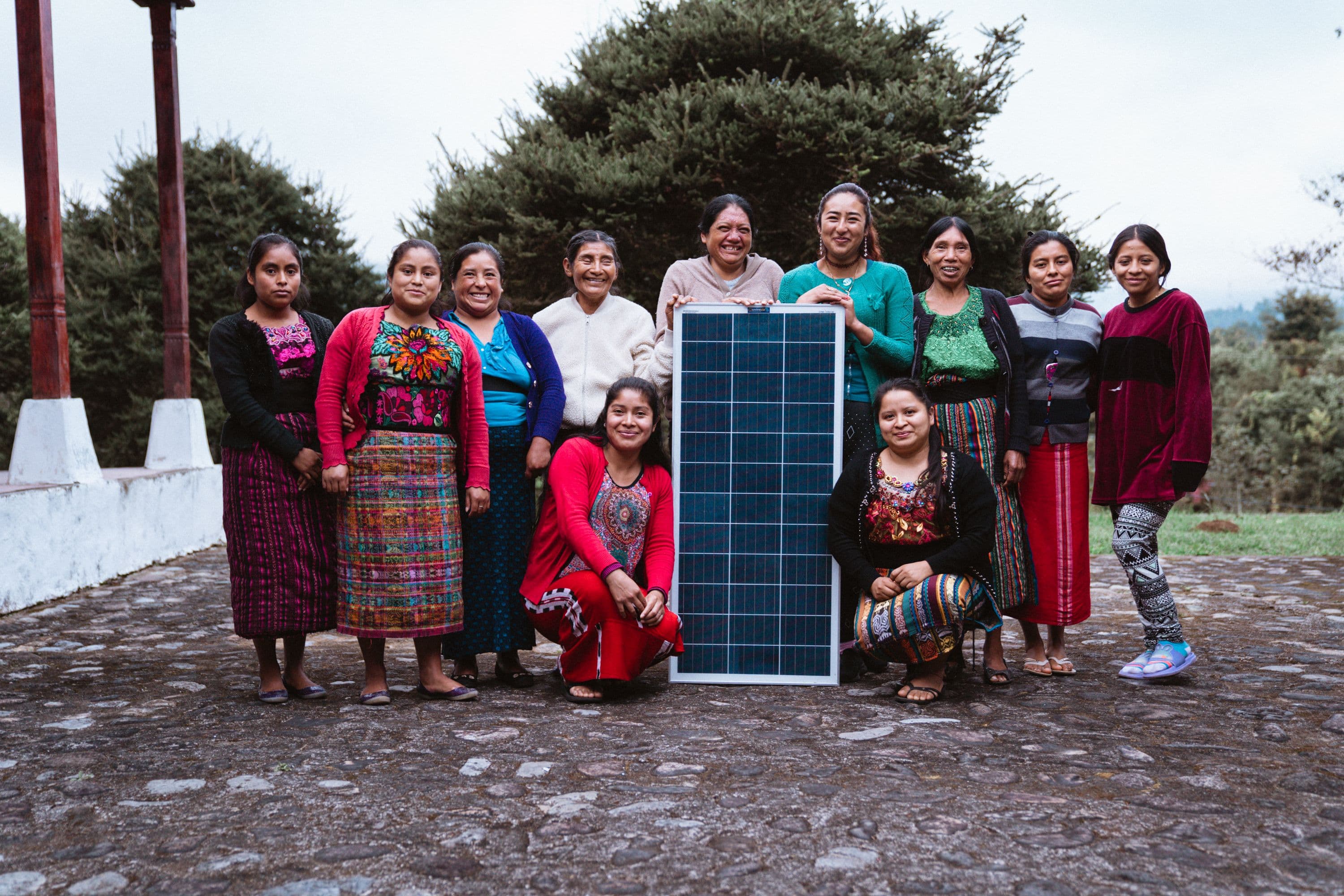 Mayan indigenous women standing with solar panel