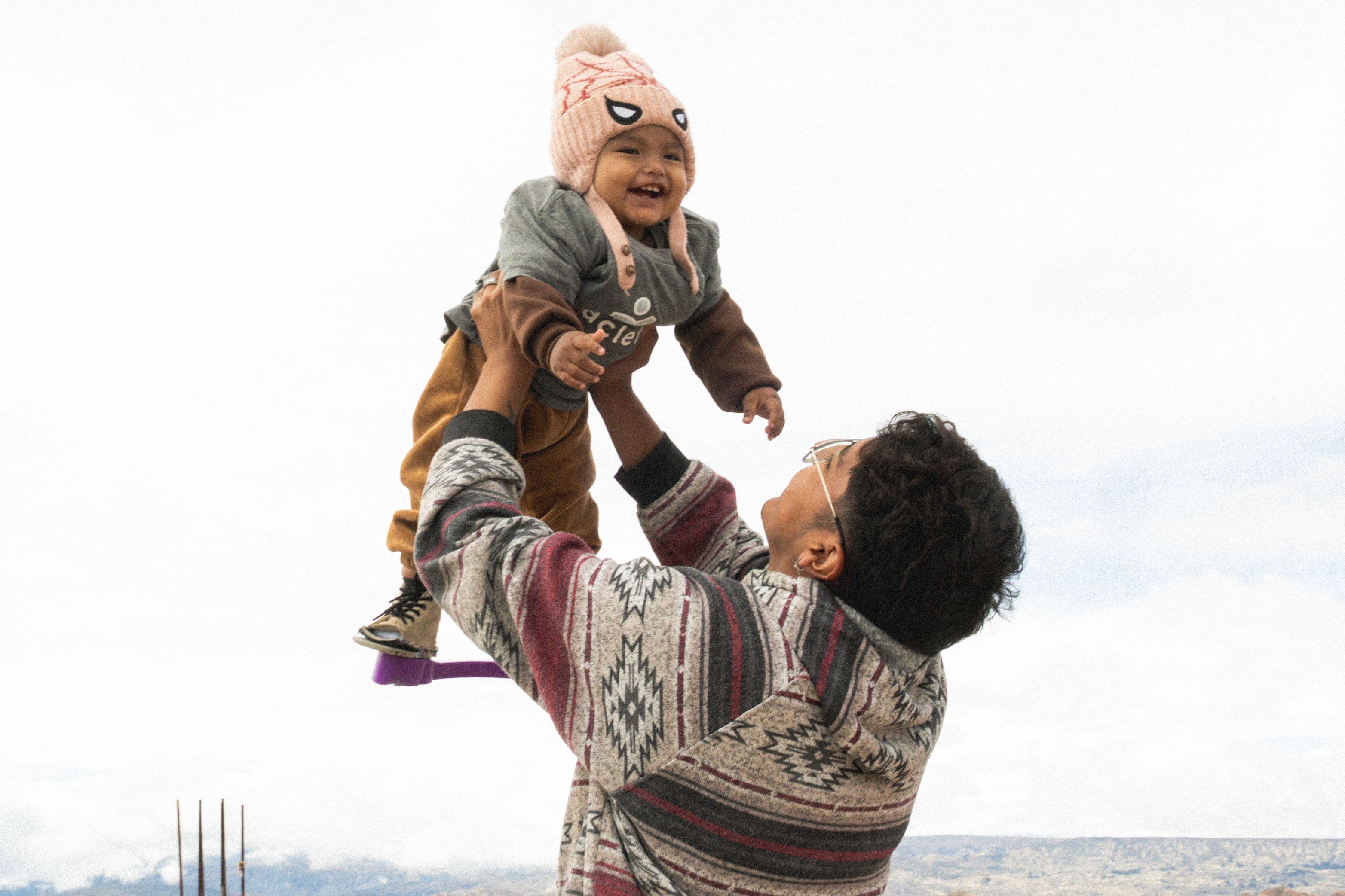 Young Bolivian baby with clubfoot treatment brace and father playing