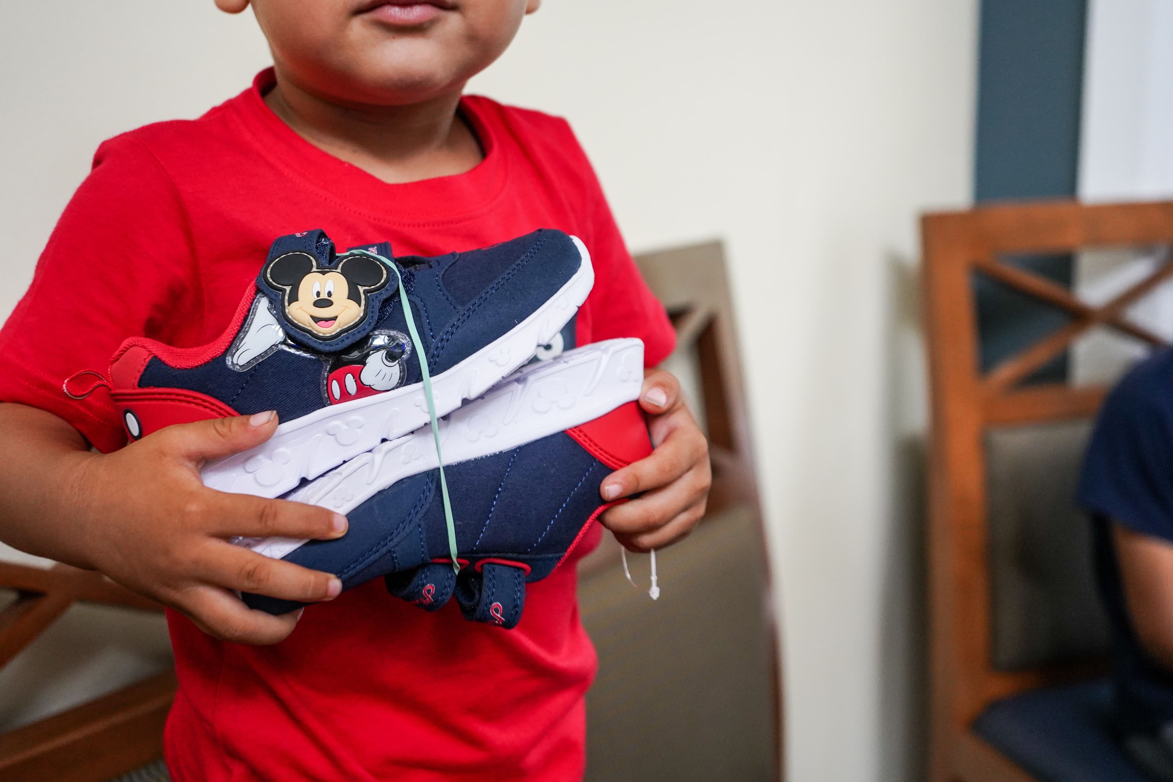 Young child receive a new pair of shoes and shoe distribution