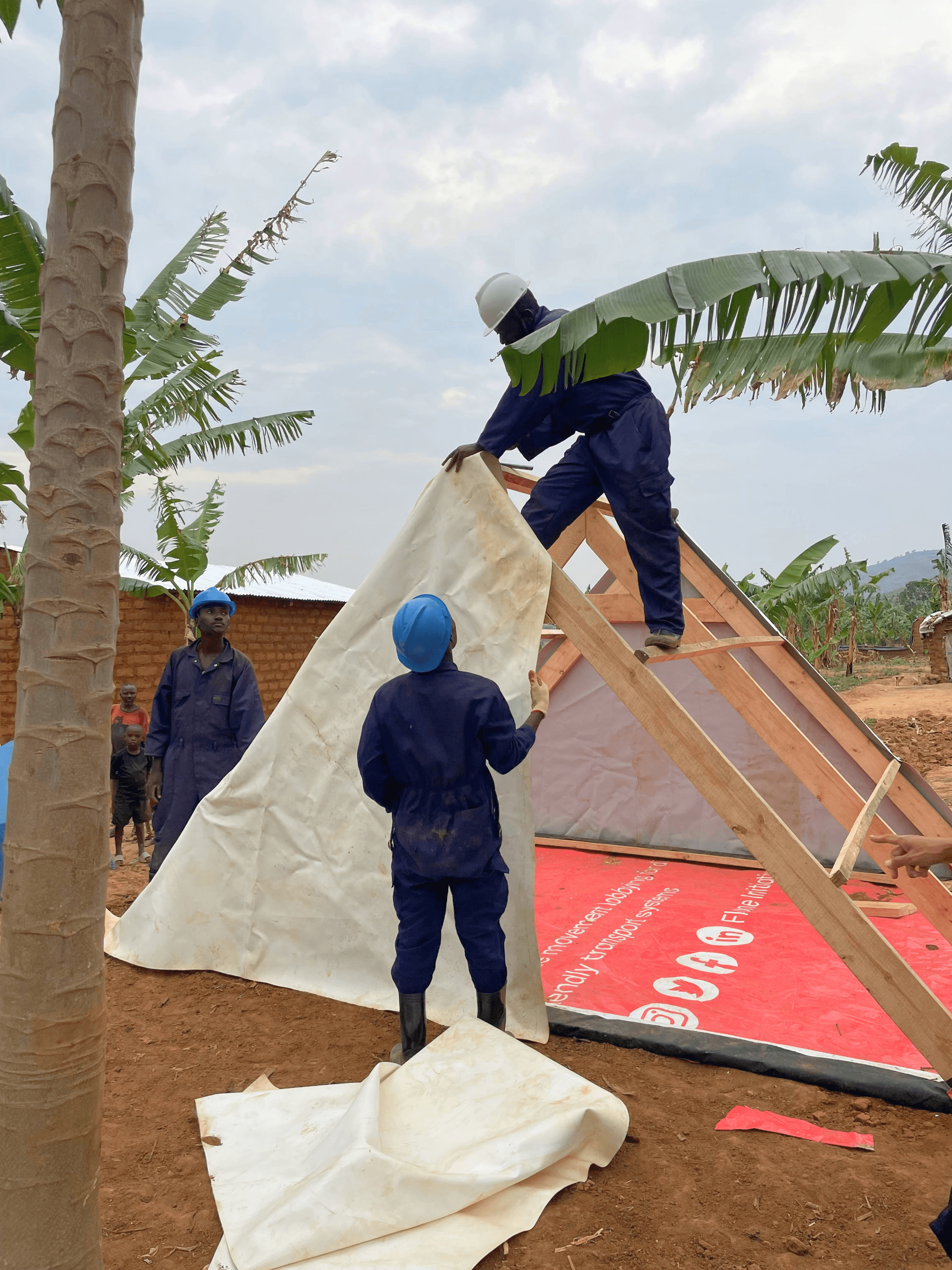 Workers building temporary, high quality shelter at refugee camp