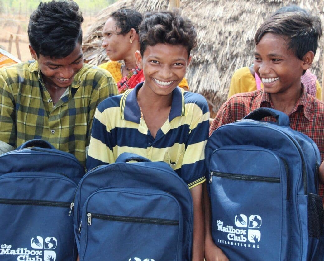 Boy smiling with his new book bag of blessing