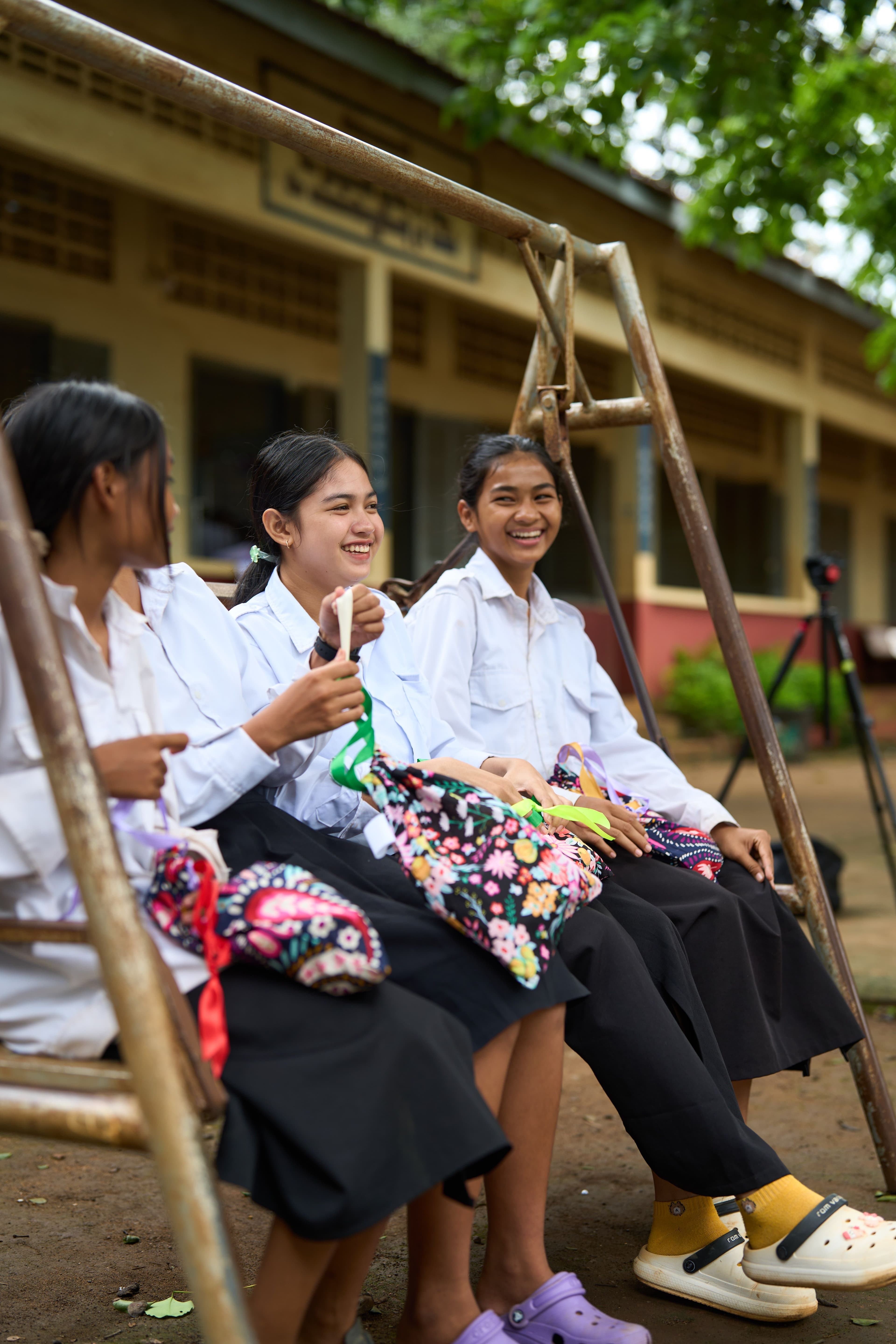 School girls laughing and talking with menstrual health kits